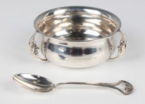 A George V silver christening bowl and matching spoon, the circular bowl with three man-in-the-