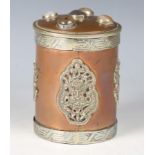 A 20th century Tibetan copper and nickel mounted cylindrical jar and cover, the lid inset with