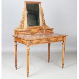 An early 20th century French walnut dressing table with carved leaf decoration, inset with a rouge