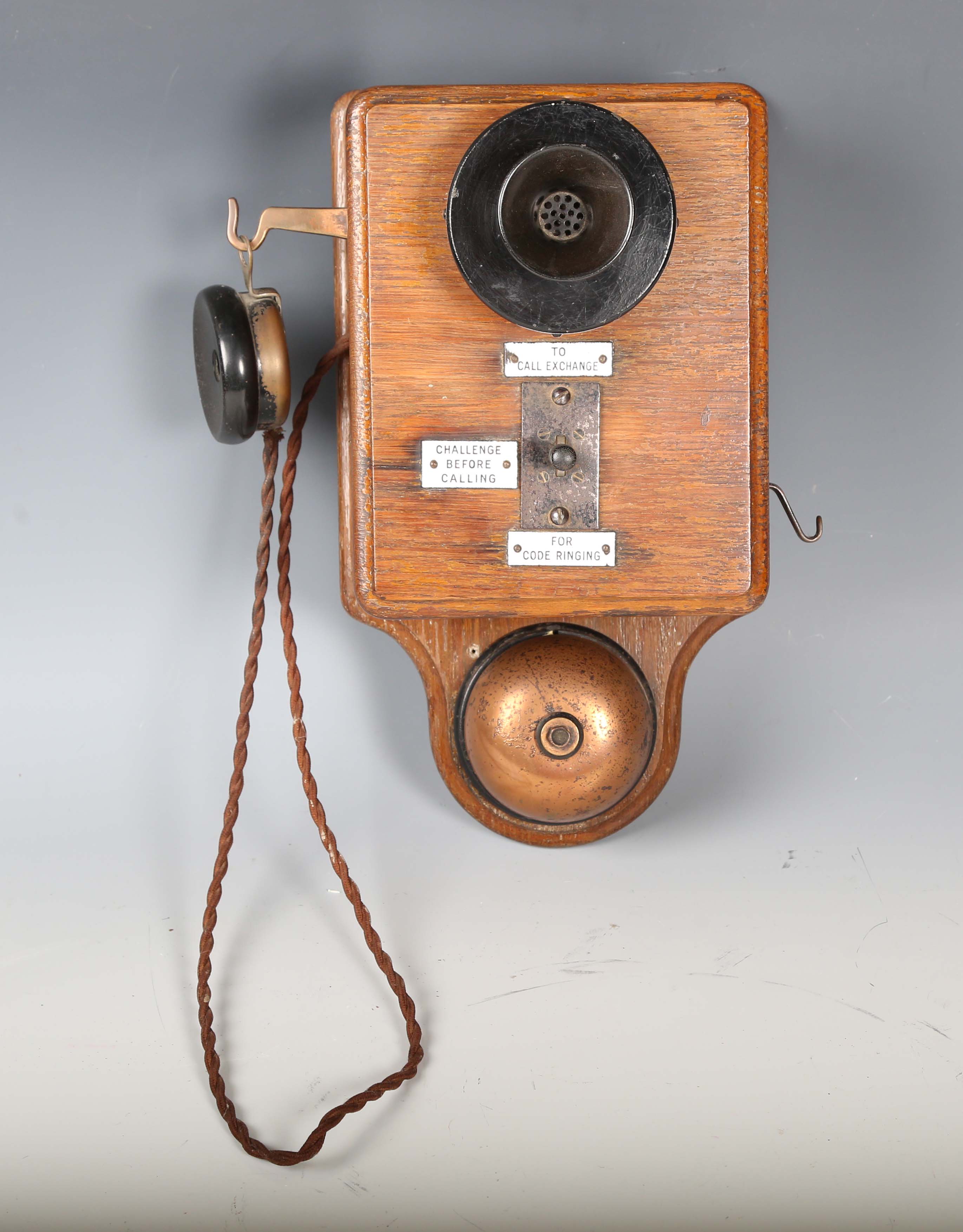 An early 20th century oak cased wall telephone, possibly from a railway, the front with applied