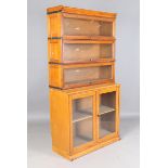 A pair of early 20th century pale oak Globe Wernicke glazed bookcases, fitted with three glazed