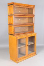 A pair of early 20th century pale oak Globe Wernicke glazed bookcases, fitted with three glazed