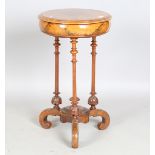 A Victorian burr walnut and inlaid circular work table, the hinged top revealing a fitted
