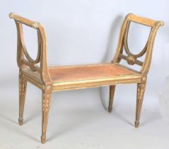 An early 20th century Neoclassical Revival giltwood window seat with lyre shaped arms and caned