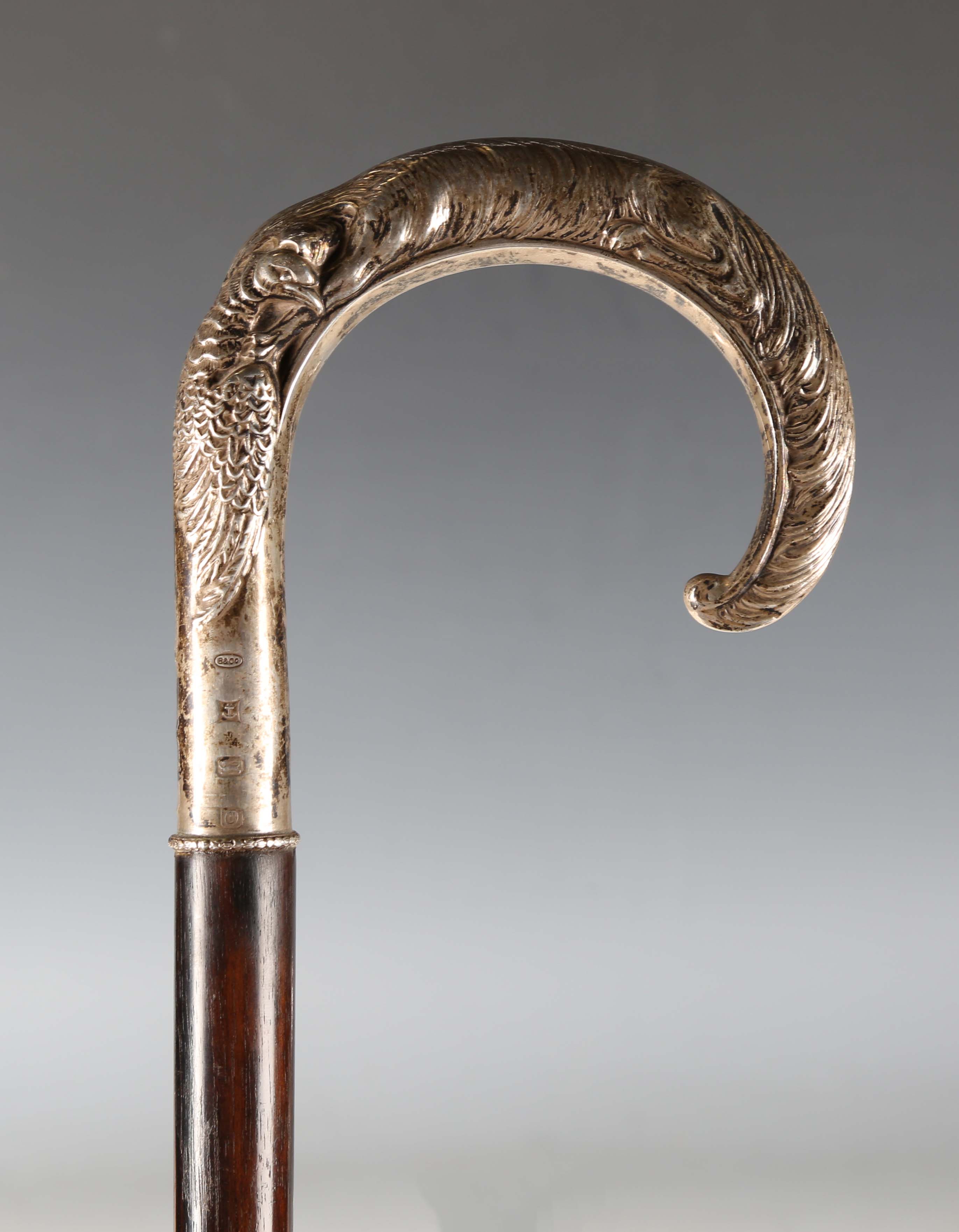 A late 20th century hardwood walking stick, the silver handle decorated in relief with a fox and