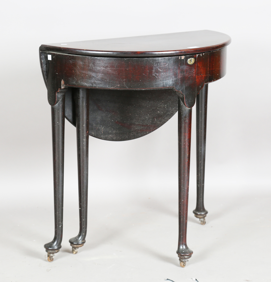 A George III mahogany demi-lune drop-flap table with hinged lid, on straight tapering legs and pad