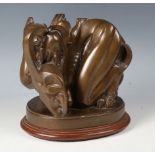 A mid-20th century brown patinated cast bronze contorted figure group depicting the Devil enveloping