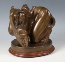 A mid-20th century brown patinated cast bronze contorted figure group depicting the Devil enveloping