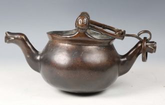A 16th century Flemish patinated bronze lavabo, the swing handle above two female mask lugs, the