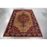 A Hamadan rug, North-west Persia, late 20th century, the camel coloured lattice field with a