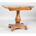 An early Victorian rosewood fold-over card table, the frieze with applied carvings, on a baluster