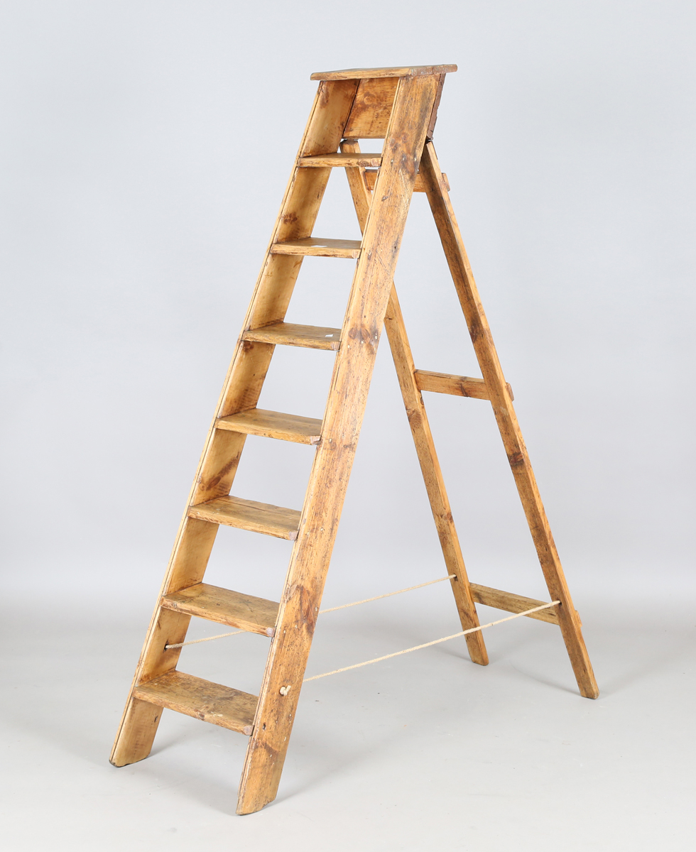 A mid-20th century stained pine eight-rung step ladder, height 167cm, width 35cm.Buyer’s Premium