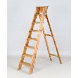A mid-20th century stained pine eight-rung step ladder, height 167cm, width 35cm.Buyer’s Premium