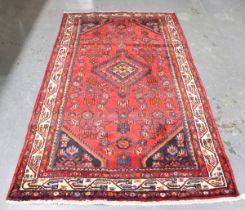 A Hamadan rug, North-west Persia, late 20th century, the red field with a lozenge medallion,