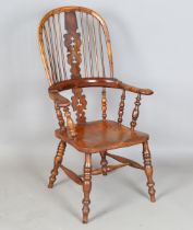 A mid-Victorian yew and elm stick and pierced splat back Windsor armchair with finely carved
