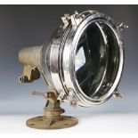 An early/mid-20th century industrial chromium plated and brass spotlight, on an adjustable base,