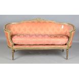 An early 20th century Louis XVI style gilt showframe salon settee, upholstered in pink damask