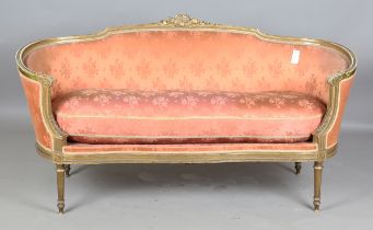 An early 20th century Louis XVI style gilt showframe salon settee, upholstered in pink damask