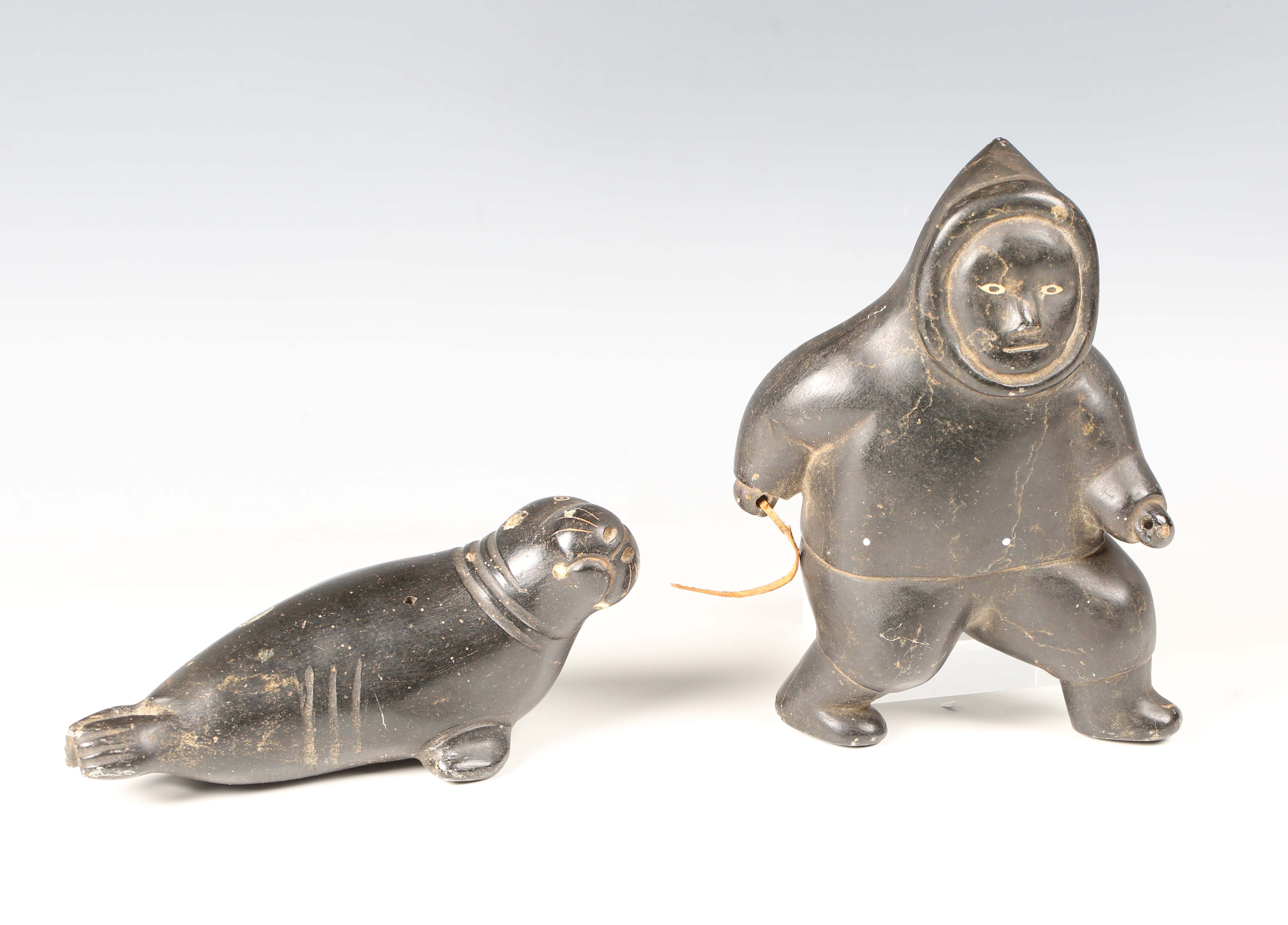 Two Inuit carved black stone figures, one modelled as an Inuit, height 19cm, the other as a