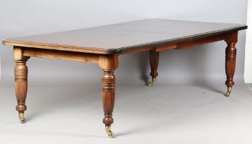 A late Victorian walnut extending dining table, raised on turned and fluted legs, height 75cm,