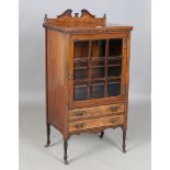 A late Victorian rosewood music cabinet, fitted with a glazed door above two drawers, on turned legs