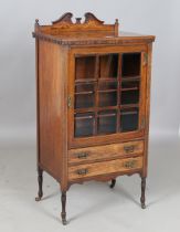 A late Victorian rosewood music cabinet, fitted with a glazed door above two drawers, on turned legs