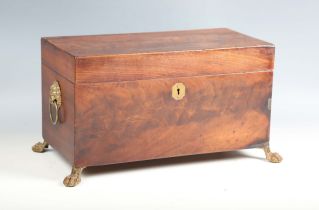 A Regency figured mahogany tea caddy with lion mask ring handles and claw feet, width 34cm.Buyer’s