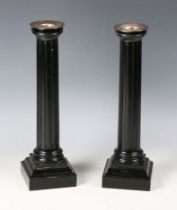 A pair of David Linley ebonized candlesticks with plated brass sconces and fluted columns,