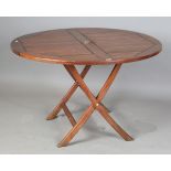 A modern teak folding circular garden table with brass fittings, height 75cm, diameter 120cm.Buyer’s