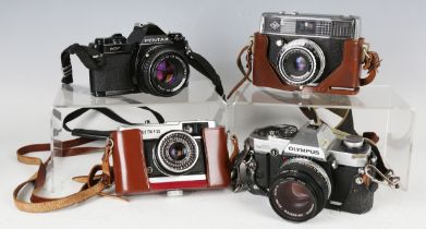 A small group of cameras, comprising an Olympus OM20 with Zuiko Auto-S 50mm 1:1.8 lens, a Pentax
