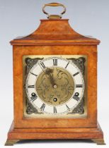 A 20th century walnut mantel clock with eight day movement chiming on gongs, the backplate