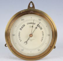 A 20th century Negretti & Zambra brass circular cased aneroid barometer with signed silvered dial,