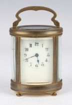 A 20th century brass oval carriage timepiece with eight day movement, the enamelled dial with