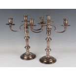 A pair of Elizabeth II silver three-light twin scroll branch candelabra, each with reeded urn shaped