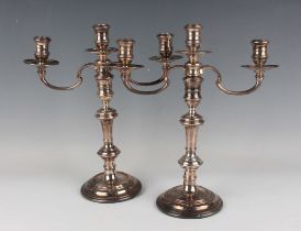 A pair of Elizabeth II silver three-light twin scroll branch candelabra, each with reeded urn shaped