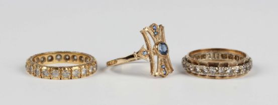 A 9ct gold and sapphire ring in a pierced panel shaped design, mounted with the principal circular