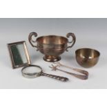 An Edwardian silver squat circular trophy cup, the gilded bowl flanked by two flying scroll handles,