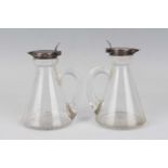 A pair of Edwardian silver mounted clear glass conical whisky tots, Birmingham 1909 by Hukin & Heath