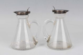 A pair of Edwardian silver mounted clear glass conical whisky tots, Birmingham 1909 by Hukin & Heath