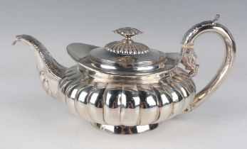 A George IV silver teapot of reeded squat circular form with foliate capped handle and scroll spout,