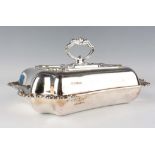 A George V silver shaped rectangular entrée dish, cover and handle, cast with foliate decoration,