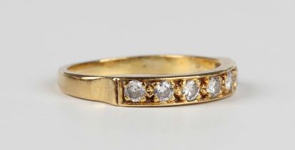 An 18ct gold and diamond seven stone half eternity ring, mounted with a row of circular cut