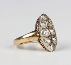 An Edwardian 18ct gold and diamond eight stone marquise shaped cluster ring, mounted with cushion