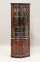 A mid-20th century reproduction mahogany bowfront corner cabinet with two lancet glazed doors,