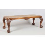 An early 20th century Queen Anne style walnut stool, the caned top on carved shell legs with claw