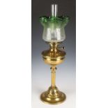 An early 20th century Arts and Crafts brass table oil lamp with an acid etched green glass shade,