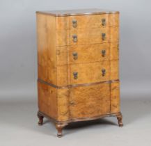 An early 20th century burr walnut serpentine fronted chest of four drawers and cupboard, height