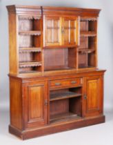 A late Victorian Aesthetic Movement walnut bookcase, fitted with cupboards and a drawer, the