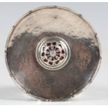 An Arts and Crafts silver and enamel circular dish with shaped border, spot hammered decoration