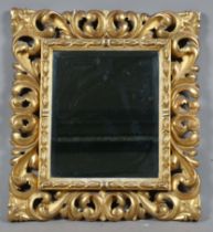 A 19th century Florentine giltwood wall mirror with foliate scrolling frame and later bevelled